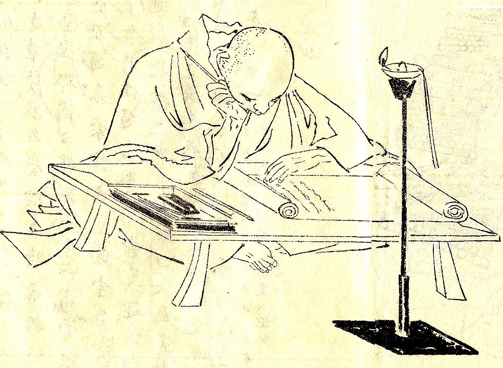 A line drawing of a monk, seated cross-legged on a floor, bending over and reading a manuscript