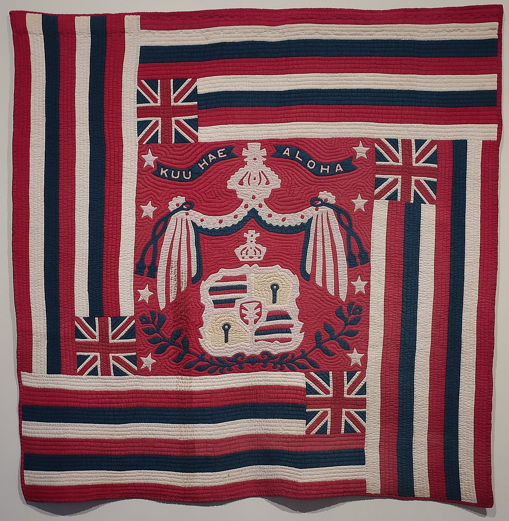 An intricately stitched quilt of the Hawaiian flag.