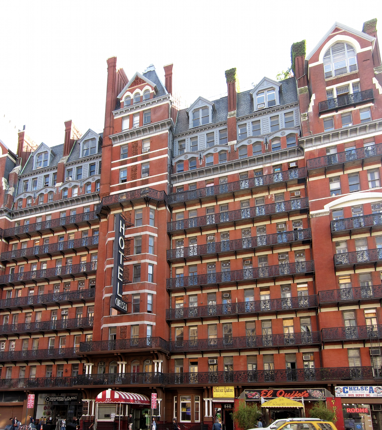 A photograph of the Chelsea Hotel in New York City, a 10-story red brick building in a multitude of archiectural styles.